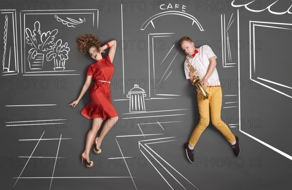 Love story concept of a romantic couple against chalk drawings background. Male playing the saxophone on the street for his girlfriend
