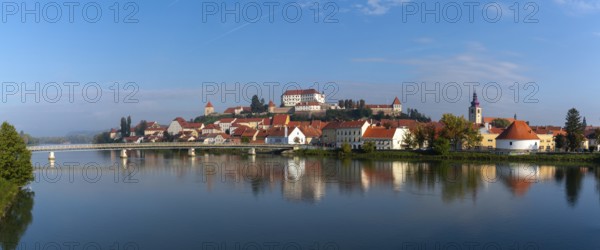 Ptuj, Slovenia, 11 October, 2022: panorama cityscape of Ptuj with the hilltop castle and reflections in the Drava River, Europe