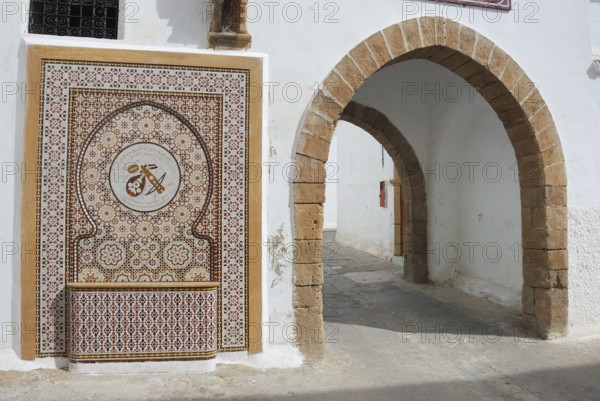 Casablanca Quartier Habous, An ornate mosaic with a traditional archway, featuring intricate patterns and earthy tones