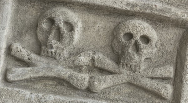 Ancient stone skull with crossbones. Old sculpture. Ideal for concepts and backgrounds
