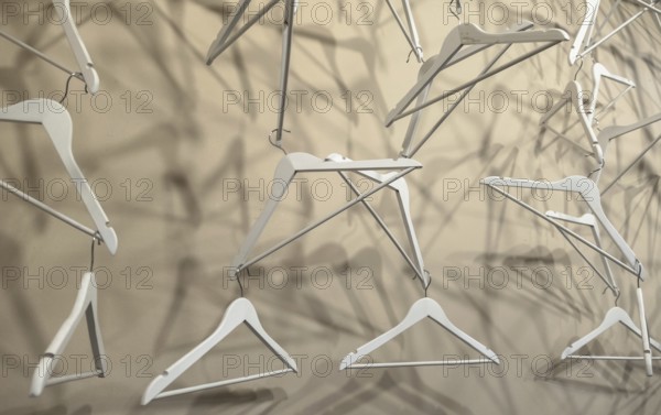 Empty wooden clothes hangers casting deep shadows. Real coat hanger wood pattern. Abstract fashion concept