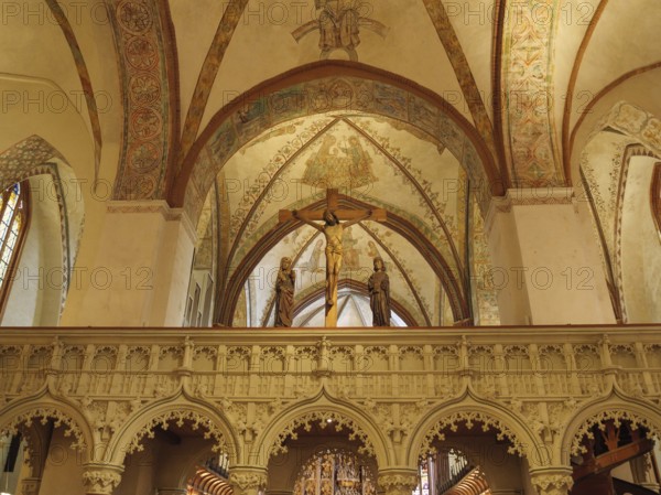Church interior with an ornate altar and Christian figures under ornate frescoes and arches, holm, schleswig. germany