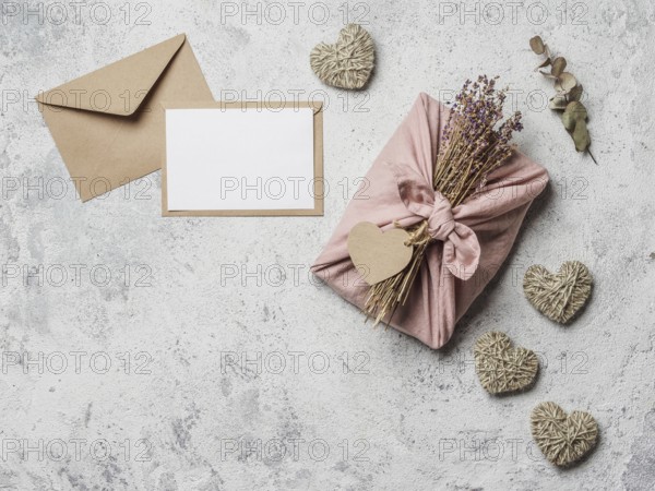 Zero waste Valentine's Day concept and mock up. Eco-friendly gift cloth wrapping in Furoshiki style, craft paper envelope, empty gift or greetings card, copy space