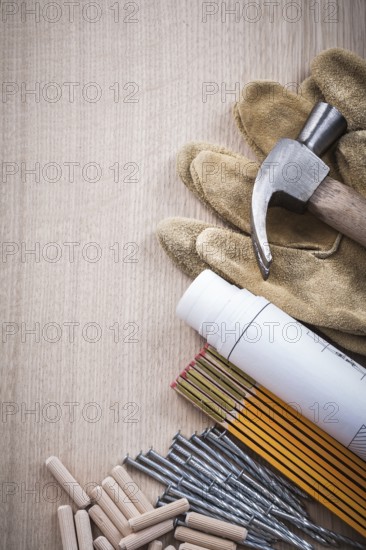 Wooden meter dowels construction plans claw hammer pair of safety gloves and nails on wood board copy space maintenance concept
