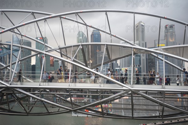 26.01.2020, Singapore, Republic of Singapore, Asia, People crossing the spiral helix bridge in Marina Bay with the skyscrapers of the business district in the background, Asia