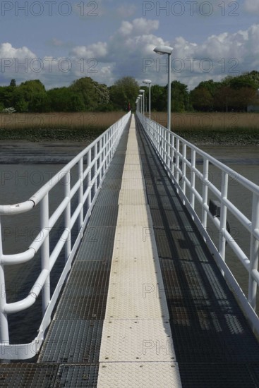 A long jetty stretches straight across the water, flanked by white railings under a blue sky, lillo, antwerp, belgium