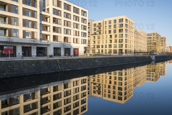 New apartment blocks in Berlin reflected in a small canal