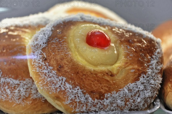 Cadiz, Province of Cadiz, Andalusia, Spain, Europe, Sweet pastry with coconut edge and red cherry in the centre, Europe