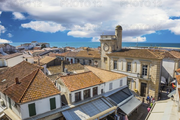 Orange and yellow tiled roofs of Provencal city Saintes-Maries-de-la-Mer. Mediterranean Sea. The concept of ethnographic tourism