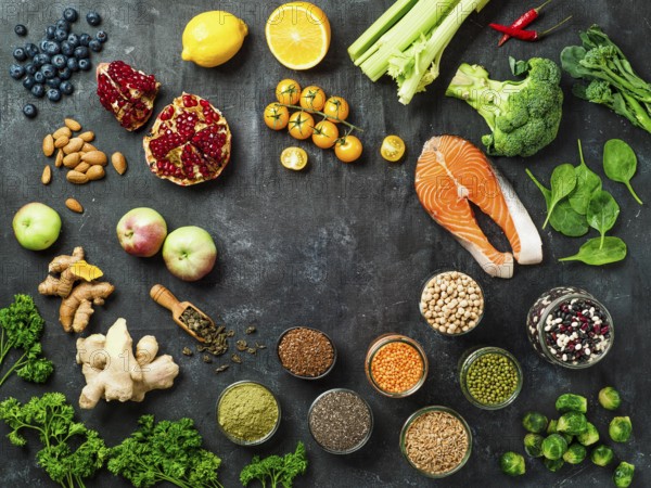 Clean Eating concept with copy space in center. Selection food ingredients for Clean Eating on dark background. Top view or flat lay