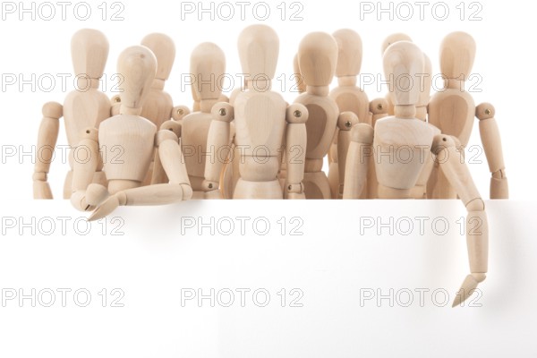 Many wooden mannequins behind board isolated over white