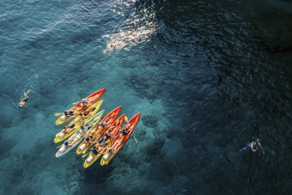 Tourists swim in the turquoise sea near a team of kayakers in kayaks. Drone., ????????