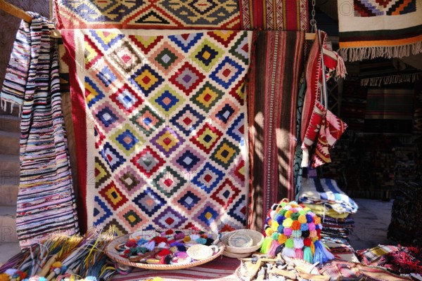 Traditional colorful berber hand woven wool carpets and rugs at middle eastern bazaar. Berber craftmanship with geometrical patterns at traditional souk