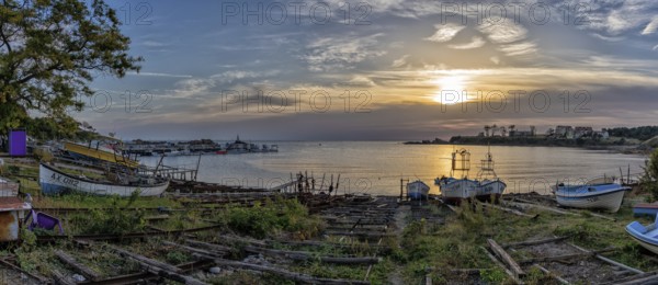 Athopol, Bulgaria, 23 October, 2022: panorama view of the boat ramps and small fishing boats in Athopol harbor on the Black Sea at sunrise, Europe