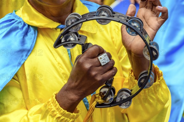 Tambourine player in colorful clothes during a performance at a traditional Brazilian religious festival