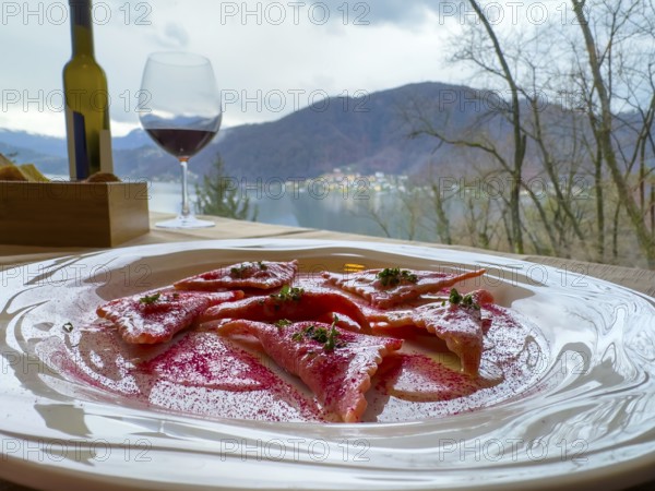 Restaurant Table with Beetroot Ravioli on a White Plate with Mountain View in Switzerland.