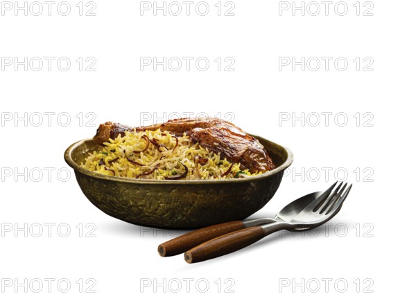 Delicious Indian dish Biryani chicken leg with basmati rice in metal brass old bowl with fork and spoon, isolated on white background. Traditional non-vegetarian food of India, food photography, food photography