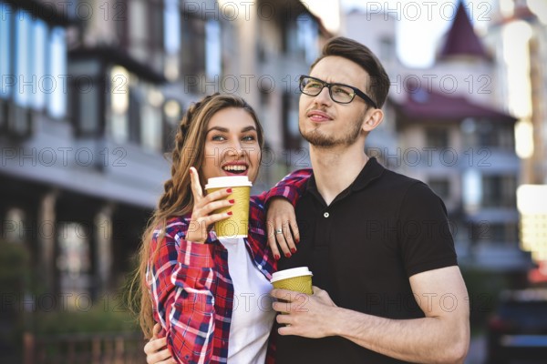 Portrait of happy couple walk on the street with coffee