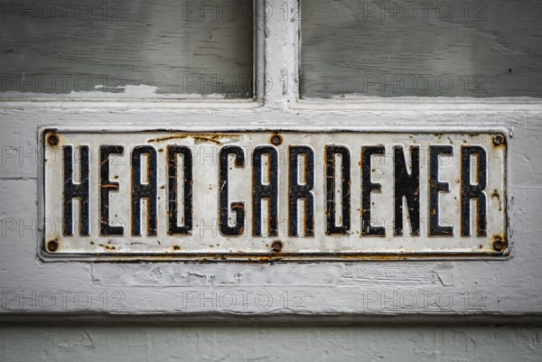A Head Gardener's Sign On A Rustic Wooden Greenhouse Door At A Stately Home