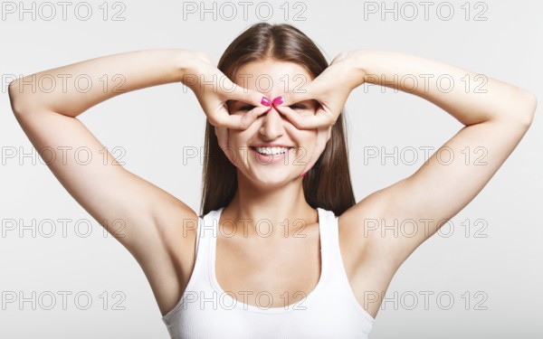 Portrait of a funny young smiling girl over gray background