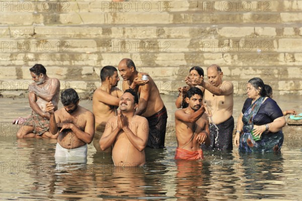 Varanasi, Uttar Pradesh, India, Asia, A group of people perform spiritual rituals in a river, in a serious atmosphere, Asia