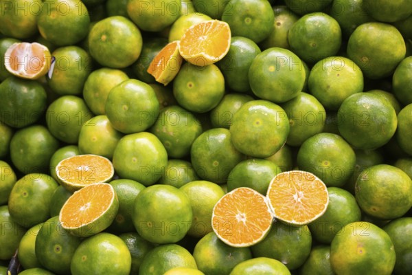 Freshly picked green tangerines mandarines, clementines, as Citrus fruit background
