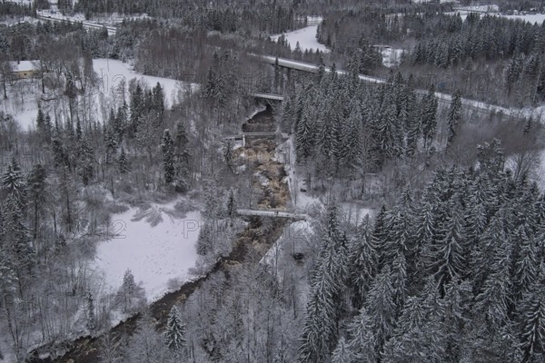 Aerial view of Myllykoski rapids on a cold winter day with snow covered ground and tree branches, Nurmijärvi, Finland, Europe