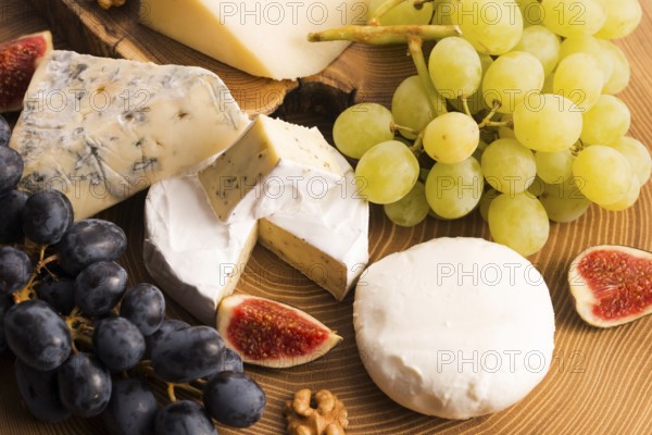 Assortment of cheese with fruits and grapes