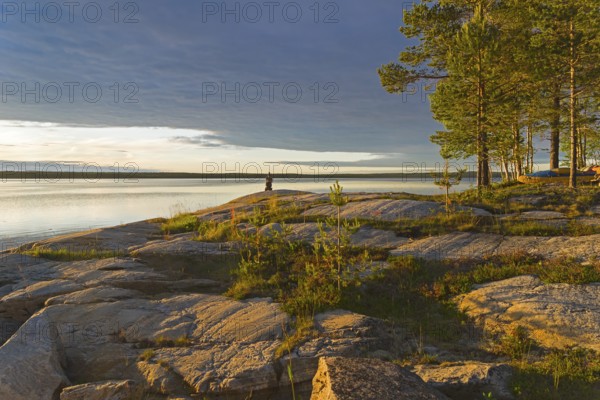 Evening on the White Sea. Stone pillar on coastal granite rock. Kandalaksha Gulf, Karelia, Russia, end of June, Europe