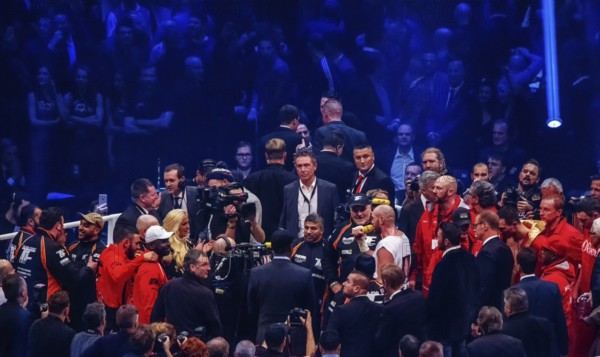 28-11-2015 Dusseldorf Germany. Tyson Fury sings for his wife (she is a cheering blonde) in a crowded ring. Brother Vitaly Klitschko and Wladimir Klitschko looking down as losers at right upper corner (so is life)
