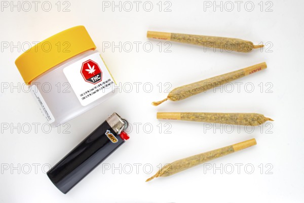 Calgary, Alberta, Canada. Aug 19, 2020. A Cannabis white and yellow plastic packaging container with Cigarettes, Prerolls or Joints and a lighter on a white background