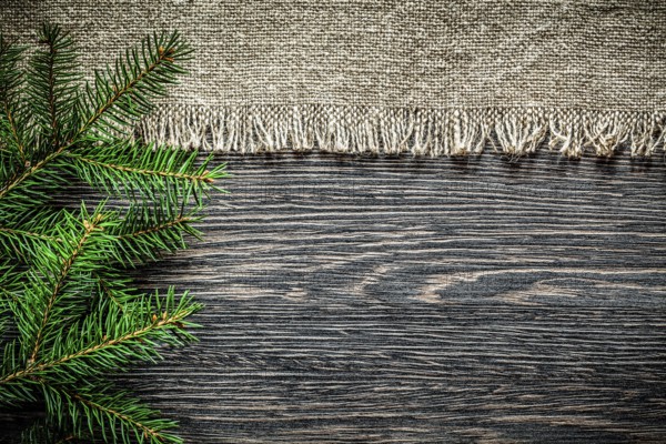 Vintage burlap pine branch on wooden board Christmas background