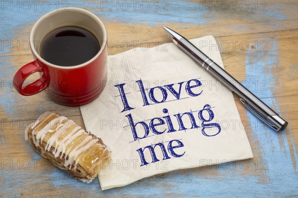 I love being me - positive affirmation - handwriting on napkin with a cup of coffee