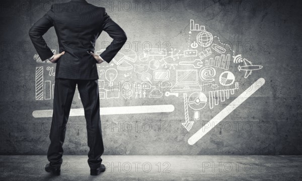Back view of confident businessman in empty concrete room