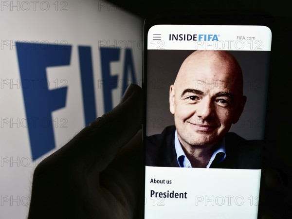 Stuttgart, Germany, 06-25-2024: Person holding cellphone with website of Federation Internationale de Football Association (FIFA) with logo. Focus on center of phone display, Europe