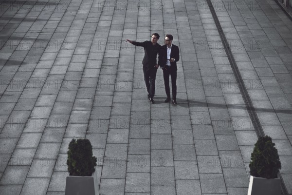 Portrait of two businessmen discussing about the new project while walking outdoors