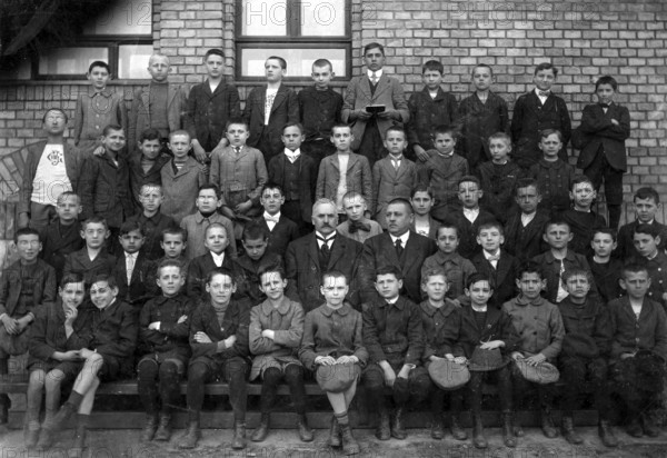 Boys school class, 1920s, Historical school class photo with boys and teachers in front of a brick building, all in formal dress, Historical photo
