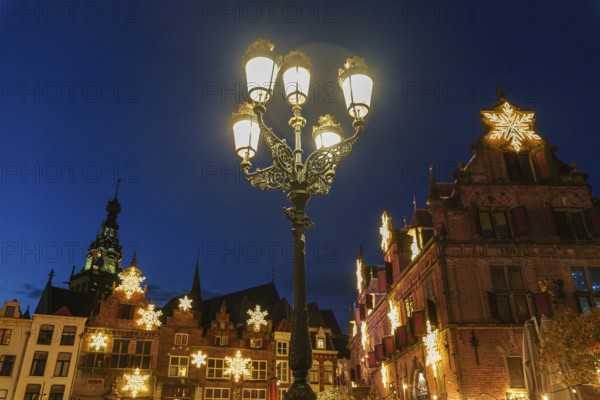 Stylish street lantern in front of festively decorated historic facades at night, nijmegen, the netherlands