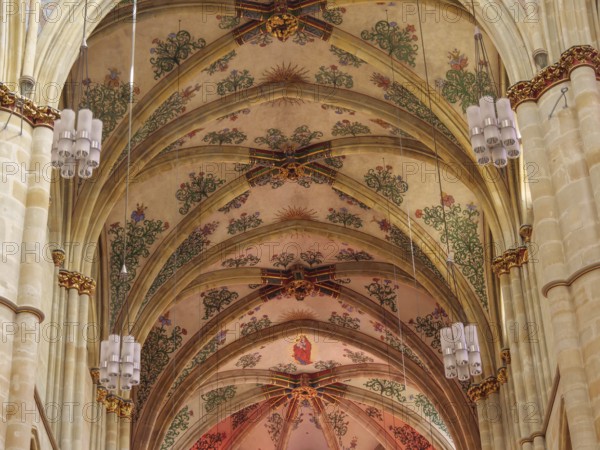 The interior of a church with ornate frescoes on the vaulted ceiling and decorative Gothic style elements, trier, germany