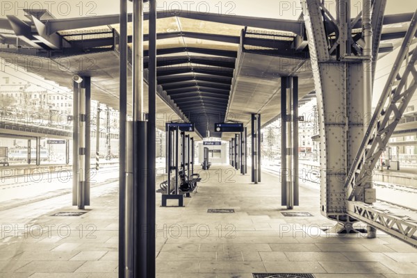 Covered platform in an empty modern railway station in sepia colour with striking metal structure, Prague Central Station