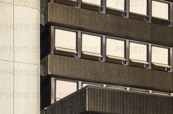 Sunlight illuminating a modernist building facade with ribbed concrete and rows of windows with sunshades, Borken, NRW, Germany, Europe