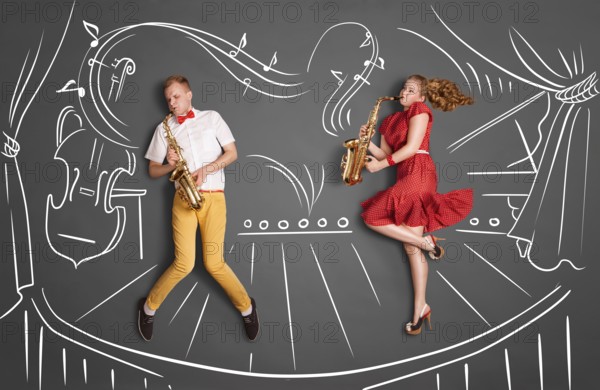 Love story concept of a romantic couple against chalk drawings background. Musician couple playing serenade on saxophone on stage