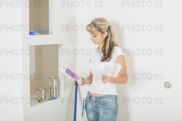 A young female painter holding color palettes and looking on it