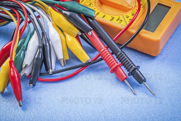 Set of crocodile plugs digital multimeter on blue background