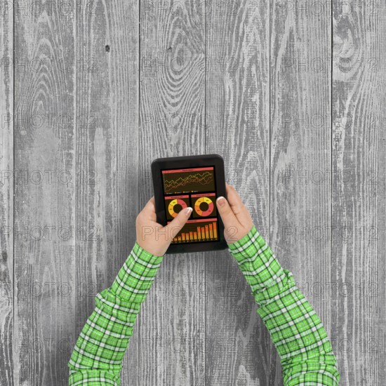 Top view of girl hands using tablet pc with diagrams and graphs on screen
