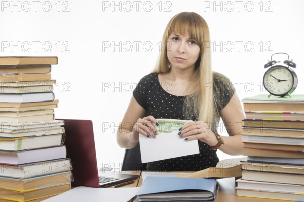 Upset girl student puts money in an envelope to bribe the teacher in the exam