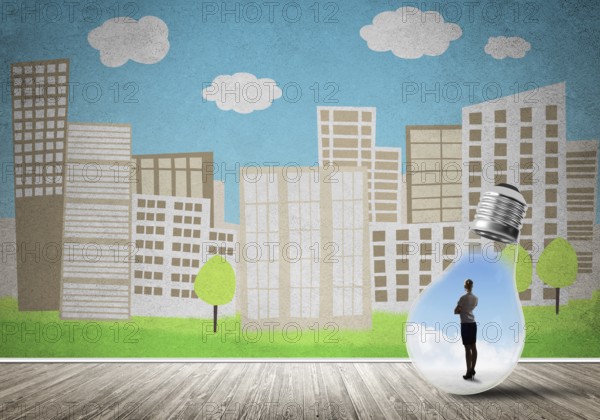 Businesswoman inside light bulb against city drawn concept