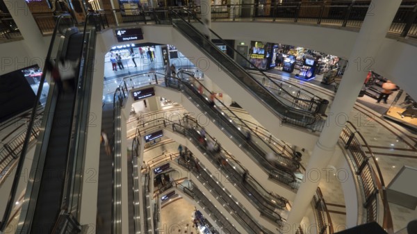 Customers in trade centre riding escalators. View from upper to lower floor. Shopping mall of Petronas Twin Towers in Kuala Lumpur, Malaysia, Asia