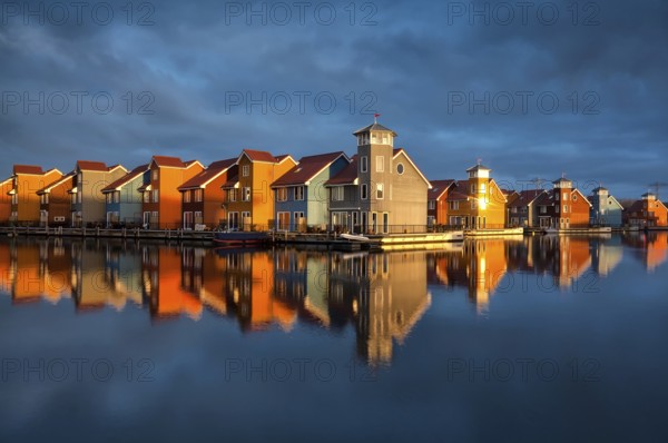 Beautiful colorful buildings on water in gold sunshine, Reitdiephaven, Groningen, Netherlands