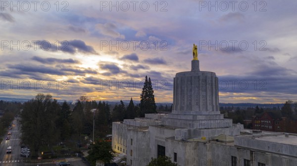 The state capital building adorned with the Oregon Pioneer with downtown Salem in the background